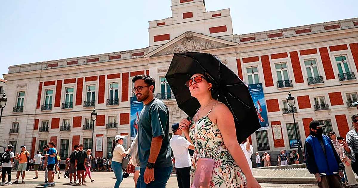 Personas se protegen del sol en Madrid durante una jornada de altas temperaturas