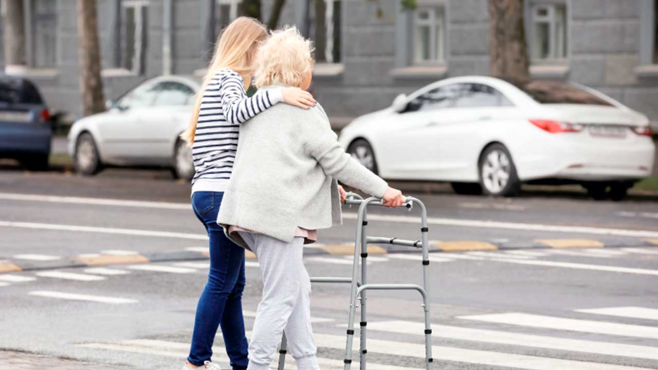 Mujer acompaña a una persona mayor durante un desplazamiento en Madrid