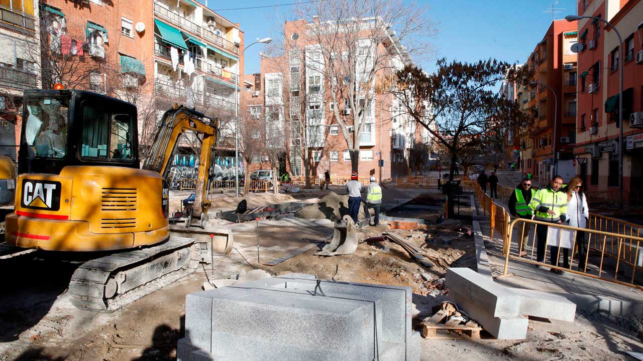 Obras de conservación de calzada en una calle de Madrid con maquinaria y señalización
