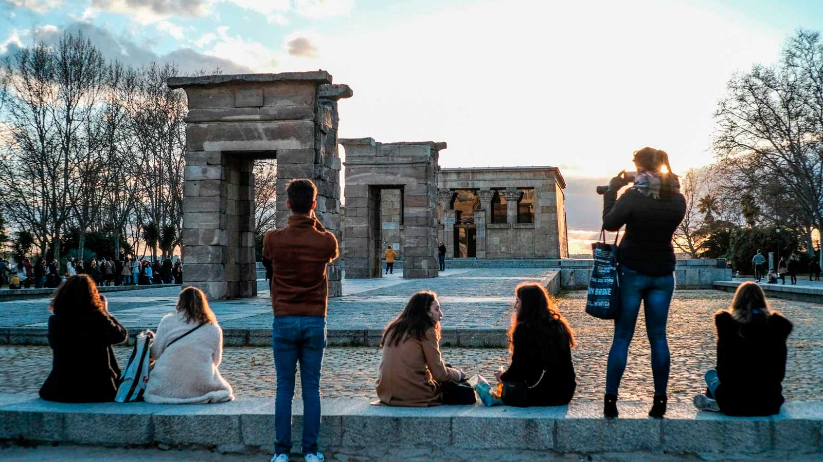 Personas contemplando el atardecer junto al Templo de Debod en Madrid