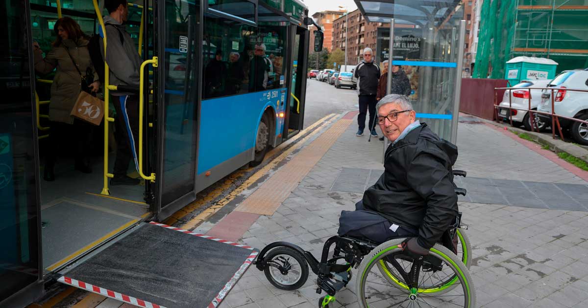 Persona en silla de ruedas junto a la rampa de acceso de un autobús en Madrid