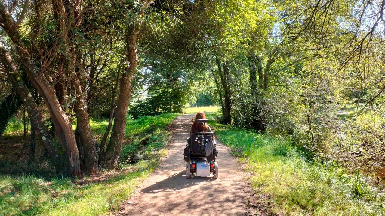 Persona en silla de ruedas recorriendo una ruta de naturaleza accesible en Madrid