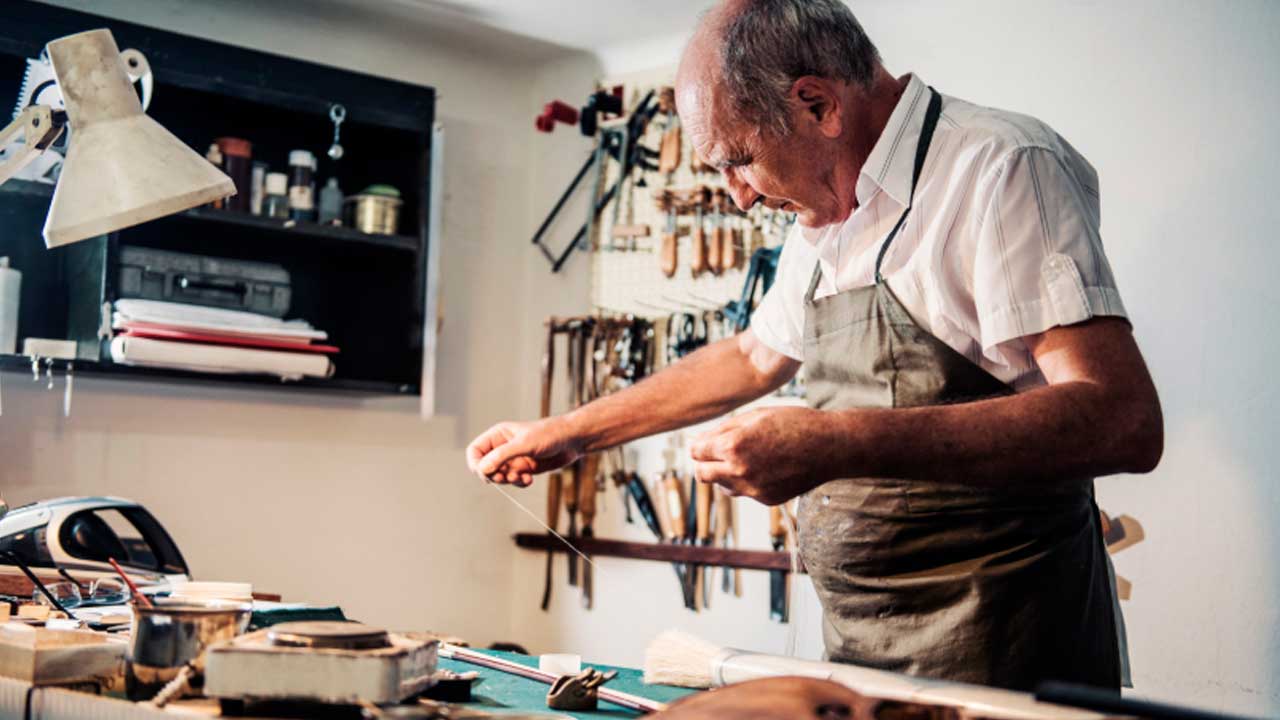 Autónomo mayor trabajando en su taller tras alcanzar la edad de jubilación