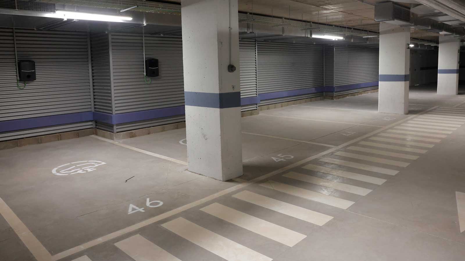 Interior del aparcamiento municipal de Fúcar en Madrid, con plazas para coches eléctricos y puntos de recarga.