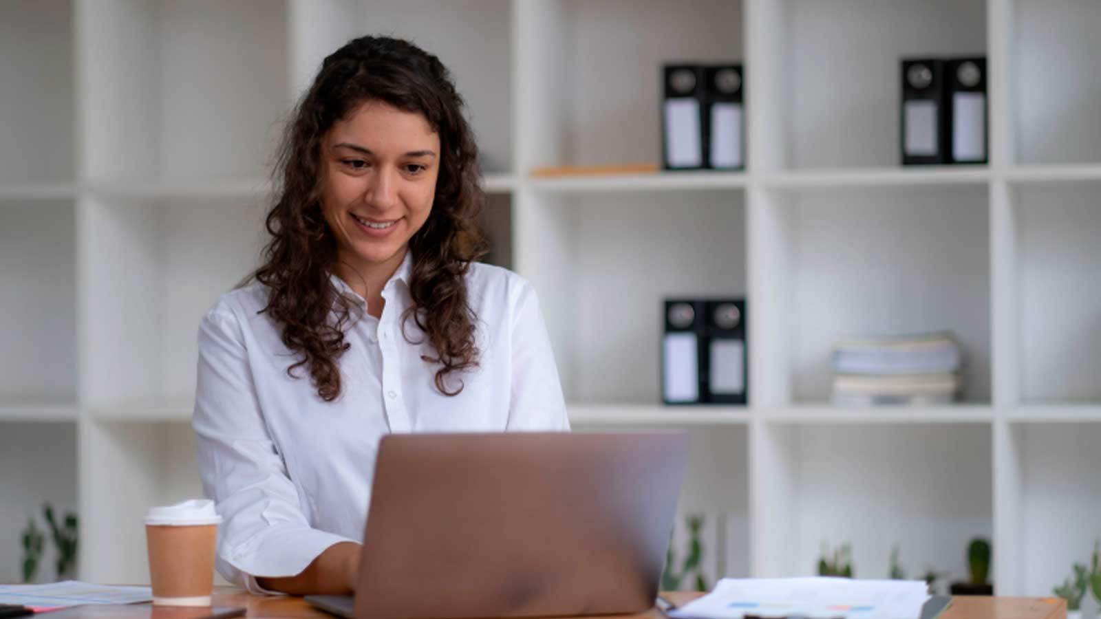 Mujer utilizando un ordenador para realizar trámites administrativos por internet.