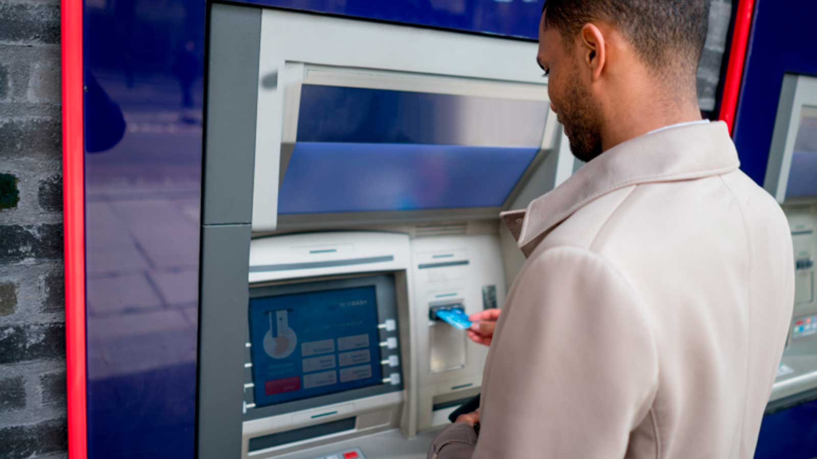 Hombre consultando un cajero para comprobar el cobro del paro en octubre de 2026