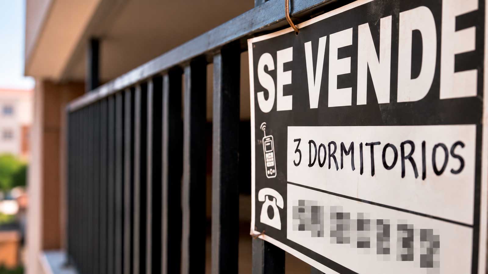 Cartel de Se Vende en el balcón de una vivienda en Madrid que ilustra la venta de una vivienda protegida a precio de mercado.