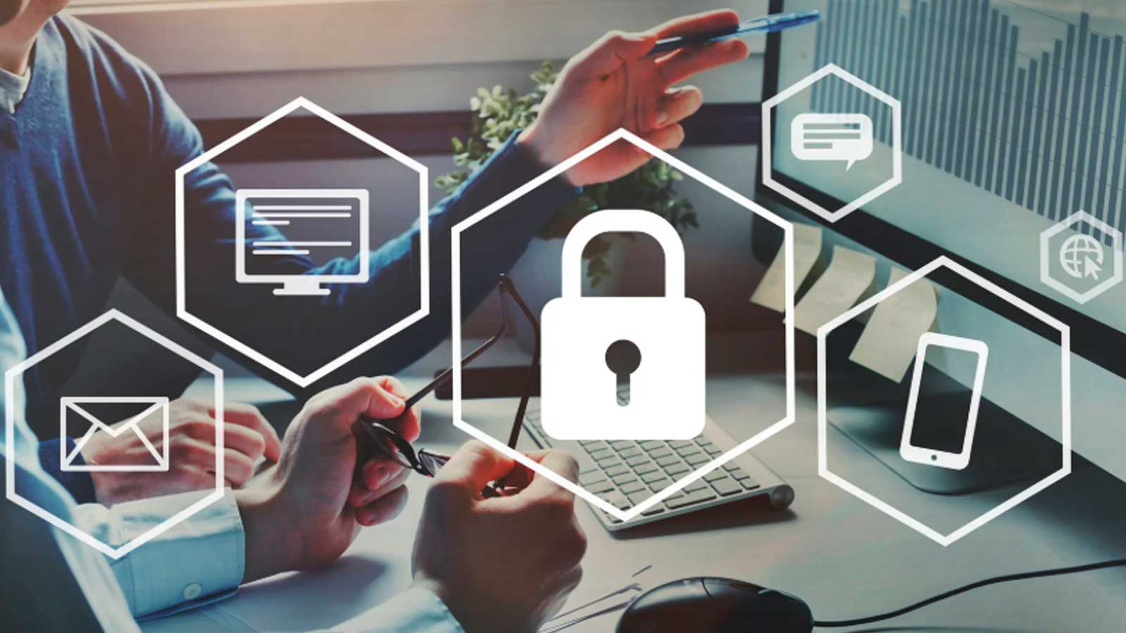 Personas trabajando con ordenadores e iconos de seguridad digital que representan un curso gratuito de ciberseguridad online en Madrid.