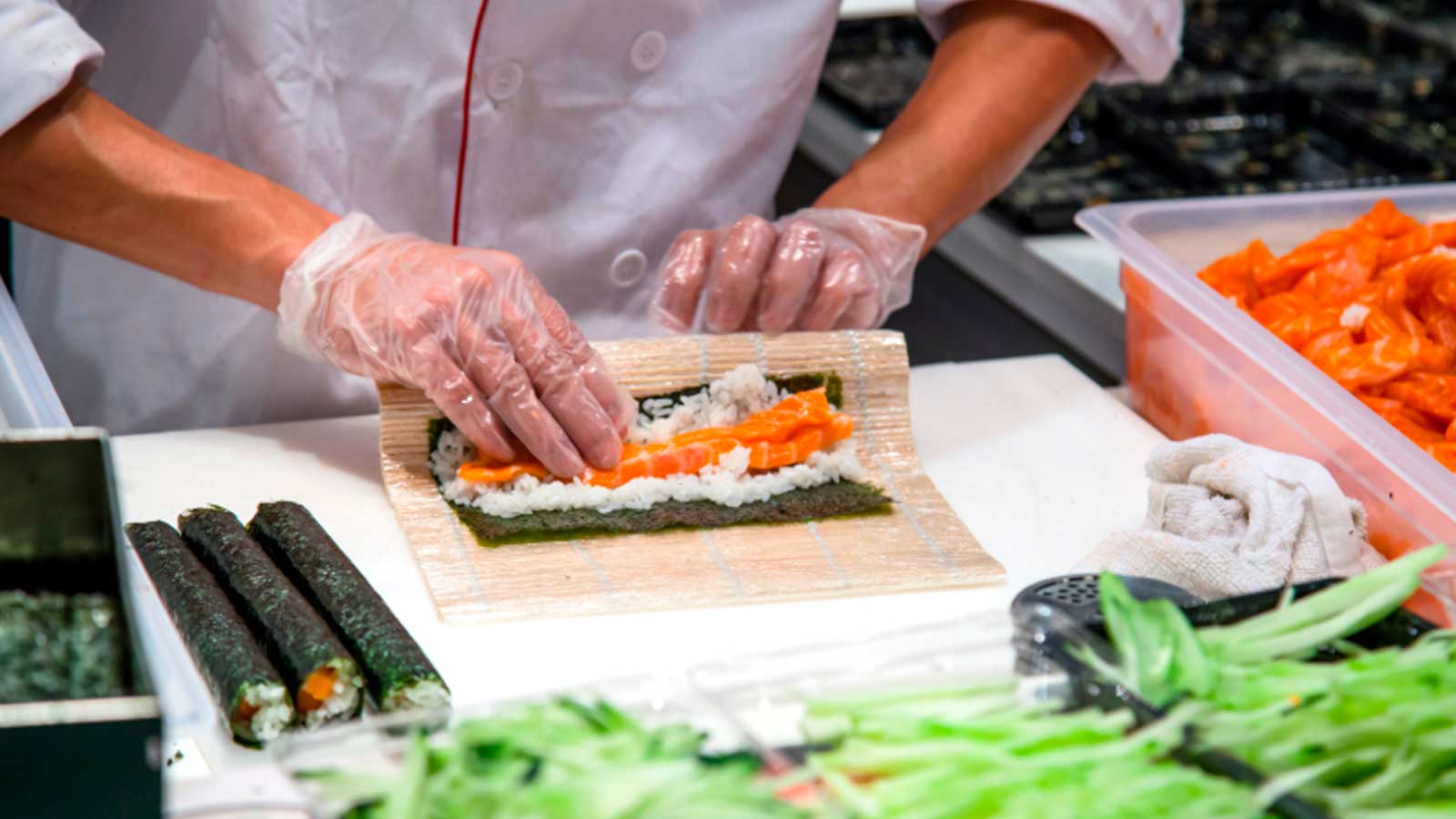 Cocinero preparando sushi durante una elaboración de cocina japonesa en un restaurante.