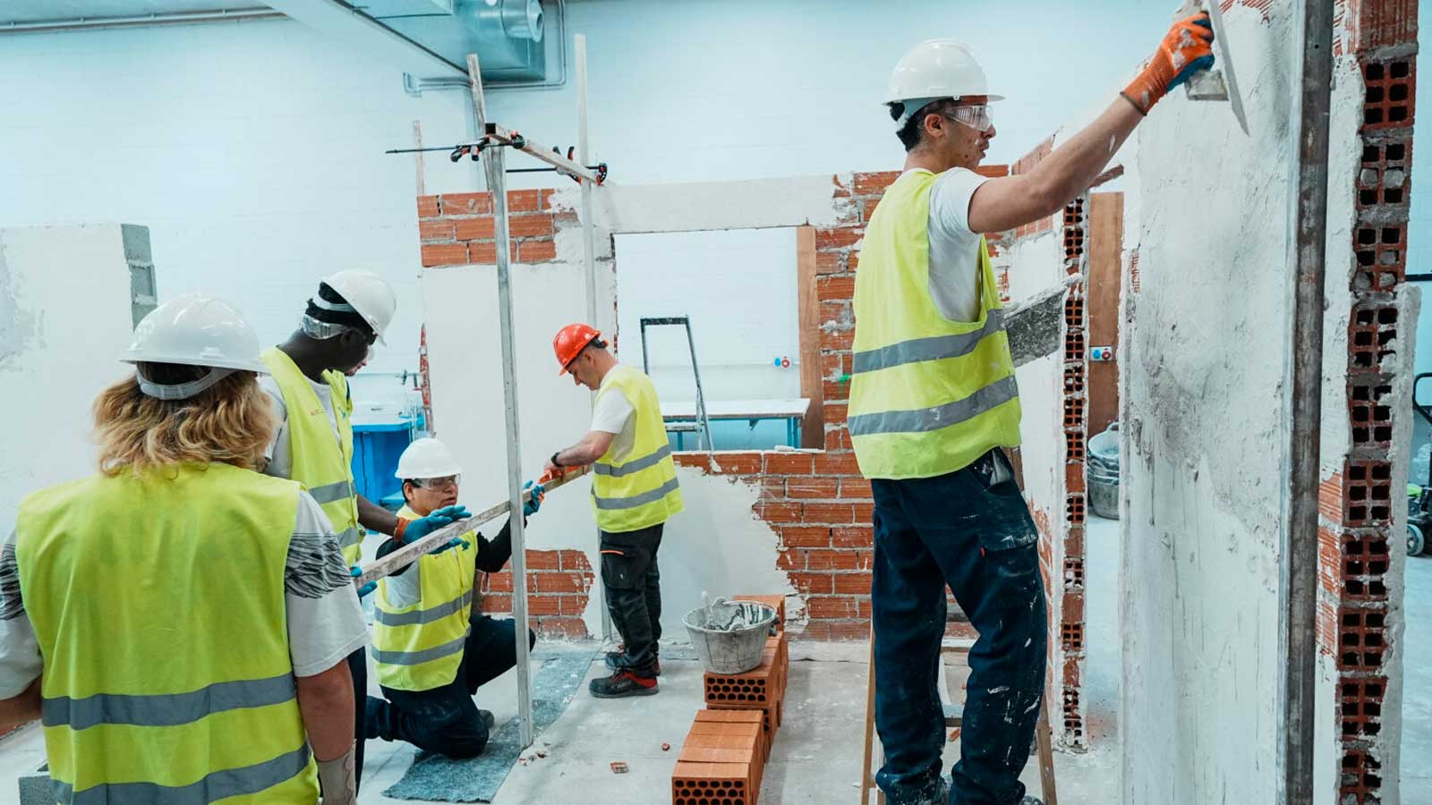 Alumnos de la Escuela Municipal de Empleo Verde y Oficios de Madrid realizan prácticas de albañilería durante un curso gratuito.