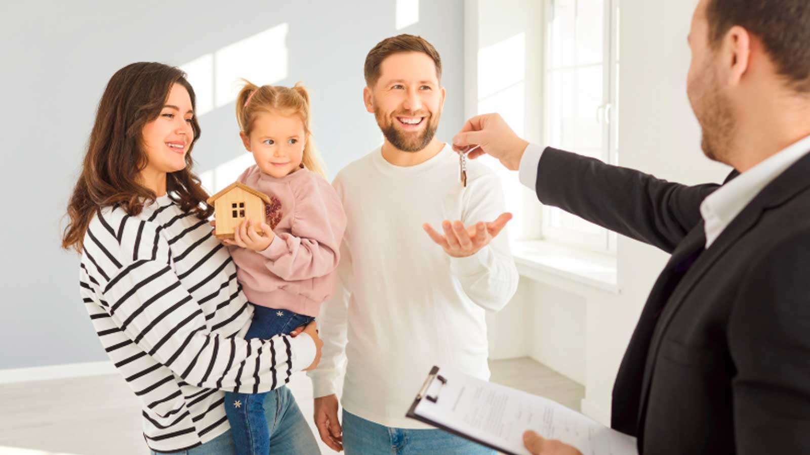 Una familia recibe las llaves de una vivienda en una imagen que ilustra el acceso a vivienda protegida en Madrid.
