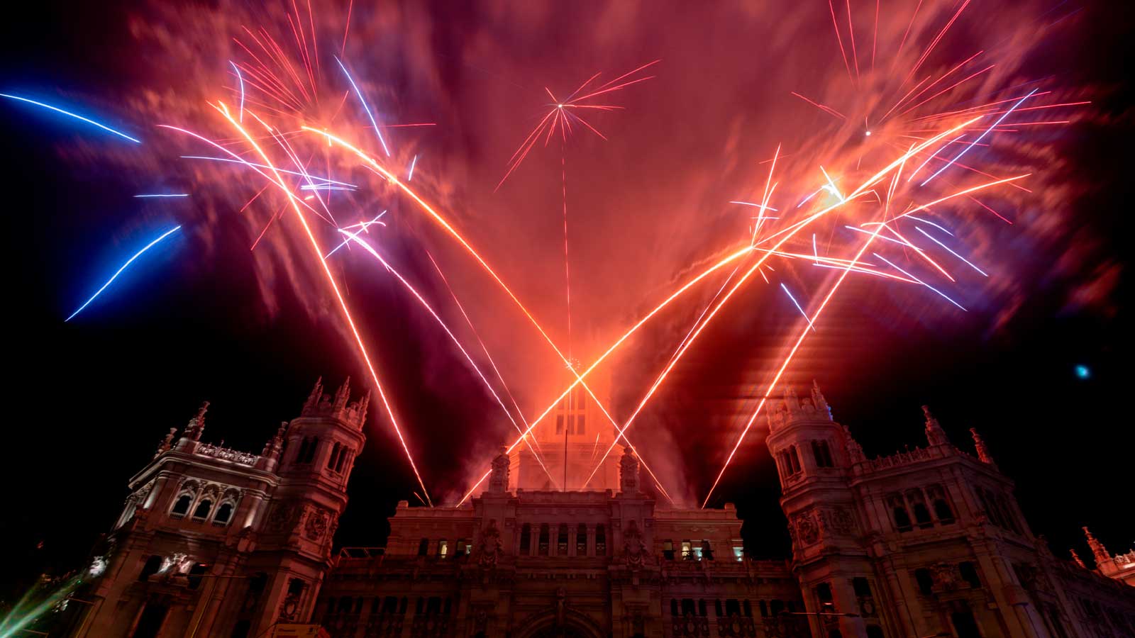 Fuegos artificiales iluminan el cielo sobre el Palacio de Cibeles en Madrid