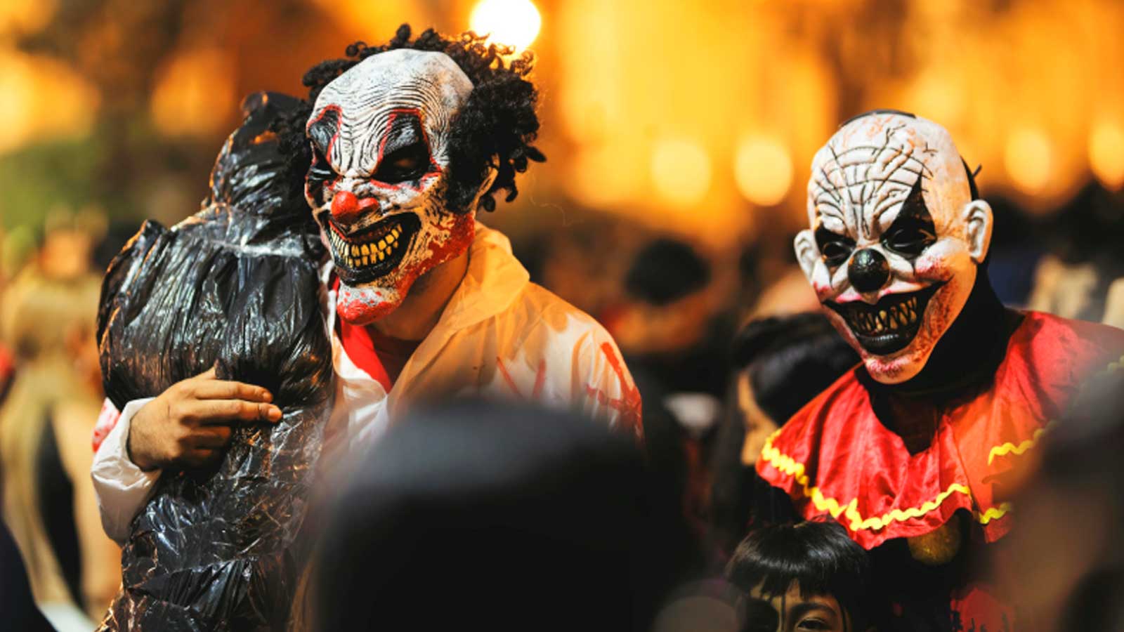 Dos personas disfrazadas de payasos terroríficos durante una celebración de Halloween.