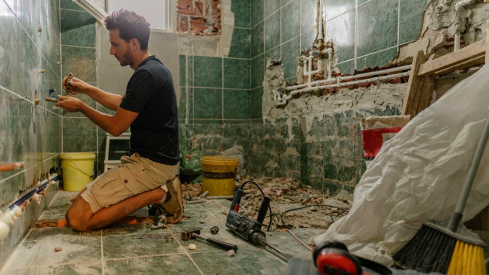 Trabajador reformando un baño en una vivienda, una de las obras que pueden financiarse con el programa ReViVa de Madrid.