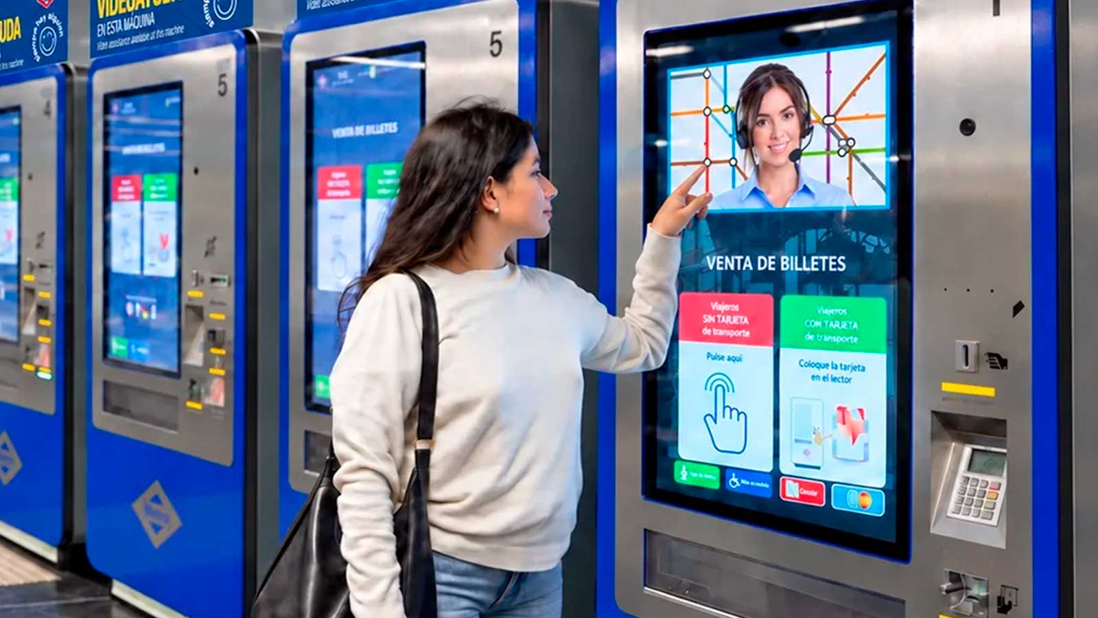 Una mujer utiliza el servicio de videollamada de Metro de Madrid en una máquina expendedora para recibir ayuda al comprar billetes.