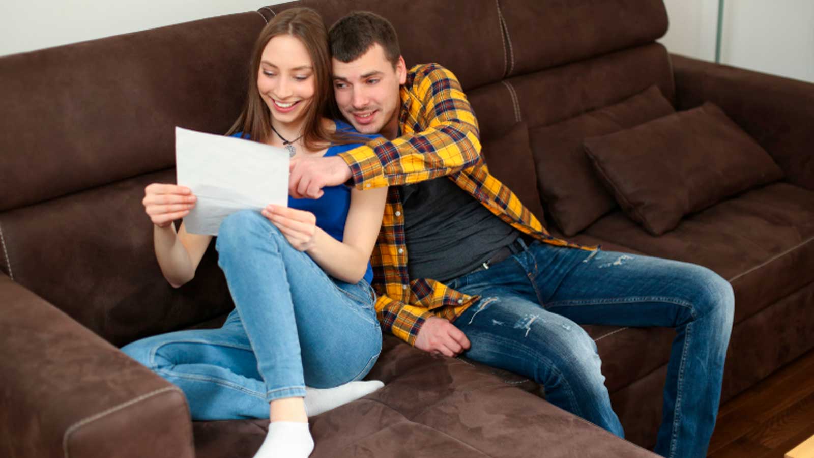 Pareja revisando un documento en su vivienda para ilustrar los requisitos de pareja de hecho en Madrid.