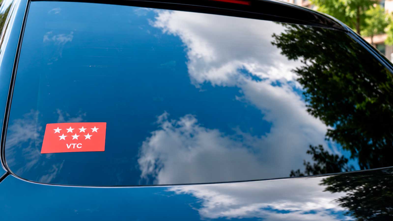 Distintivo VTC en un vehículo de Madrid, donde el permiso autonómico es obligatorio para los conductores