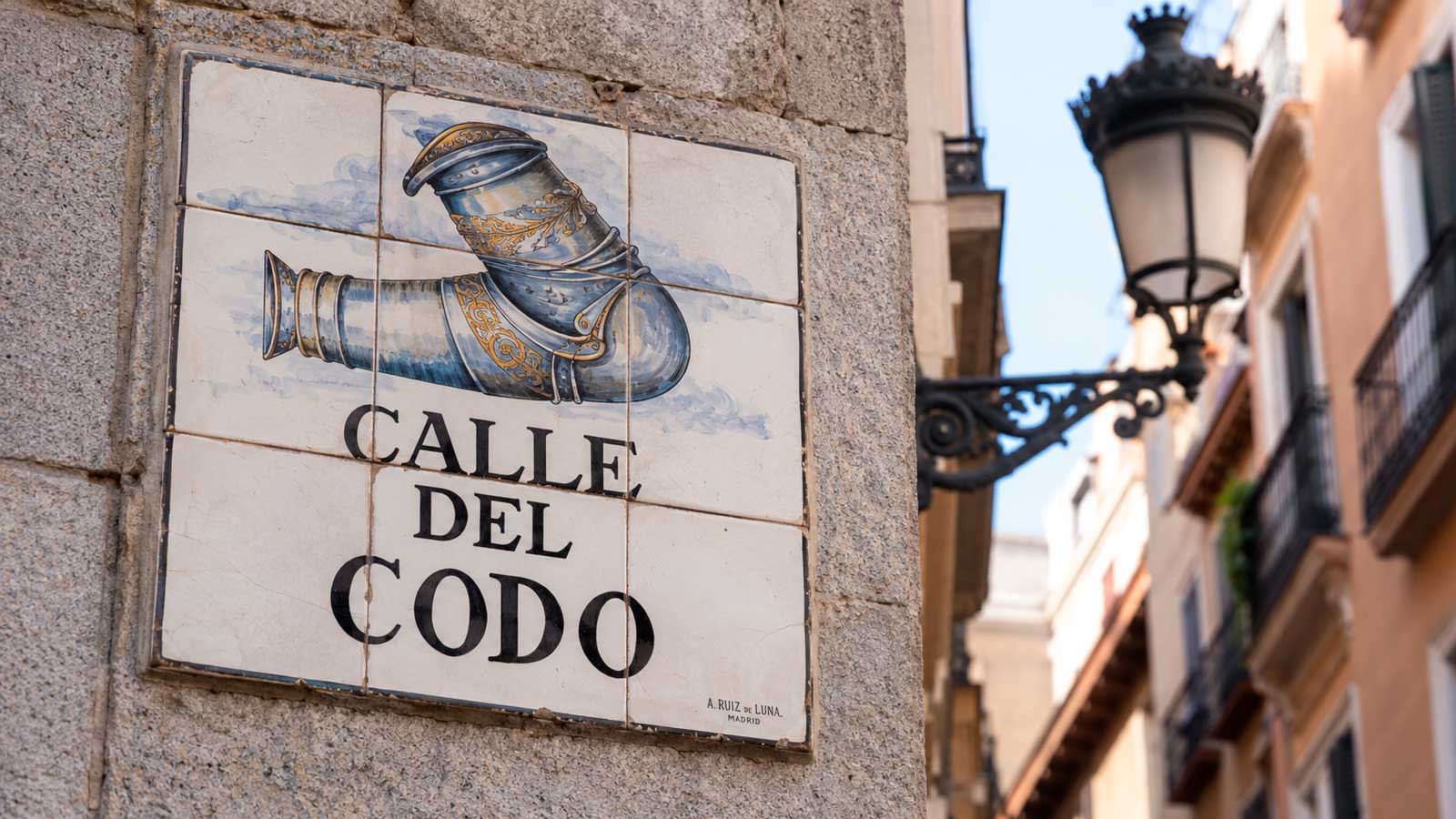Placa cerámica de la calle del Codo de Madrid con el dibujo de una pieza de armadura