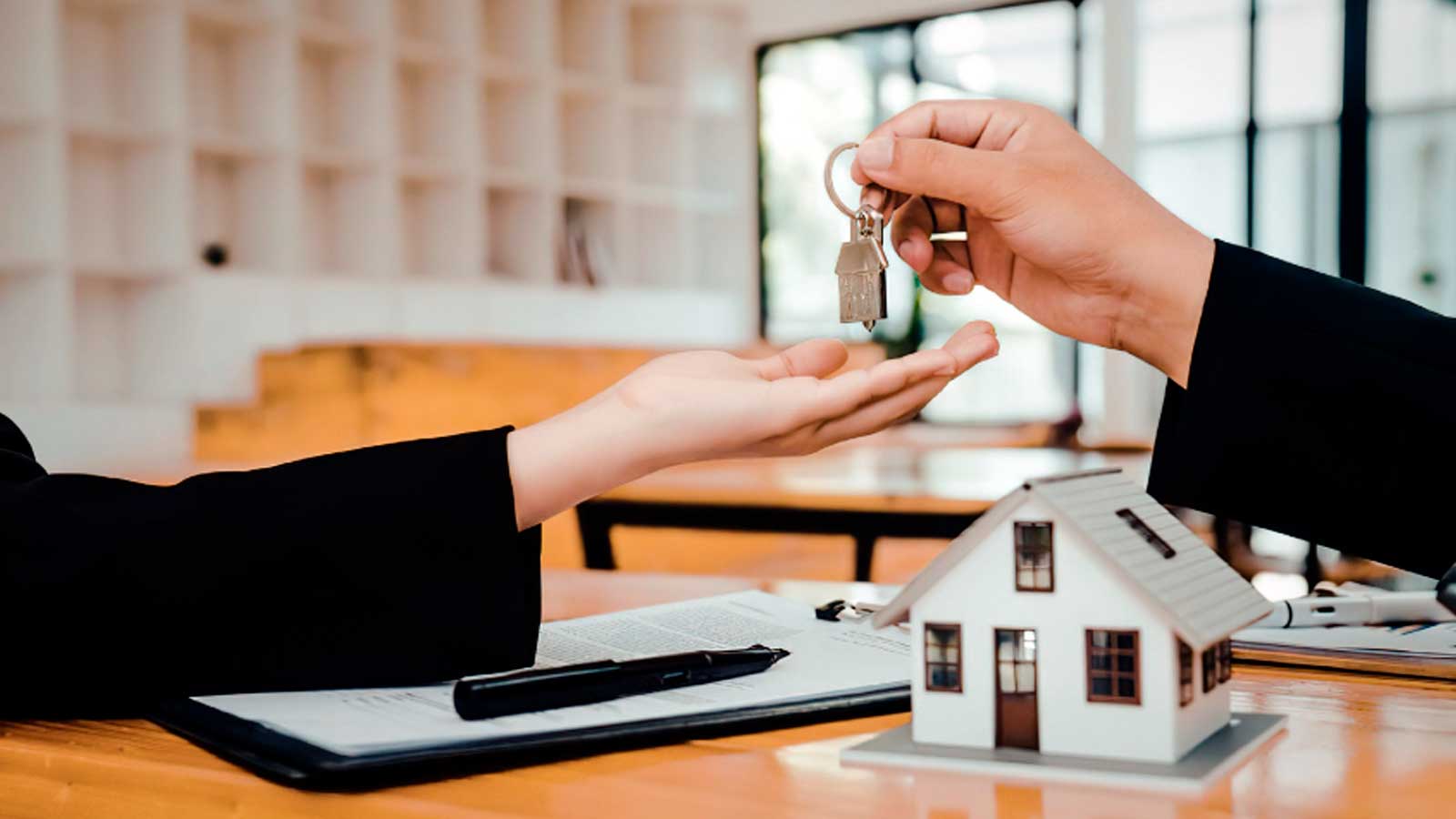 Entrega de llaves de una vivienda durante la formalización de un contrato de alquiler.