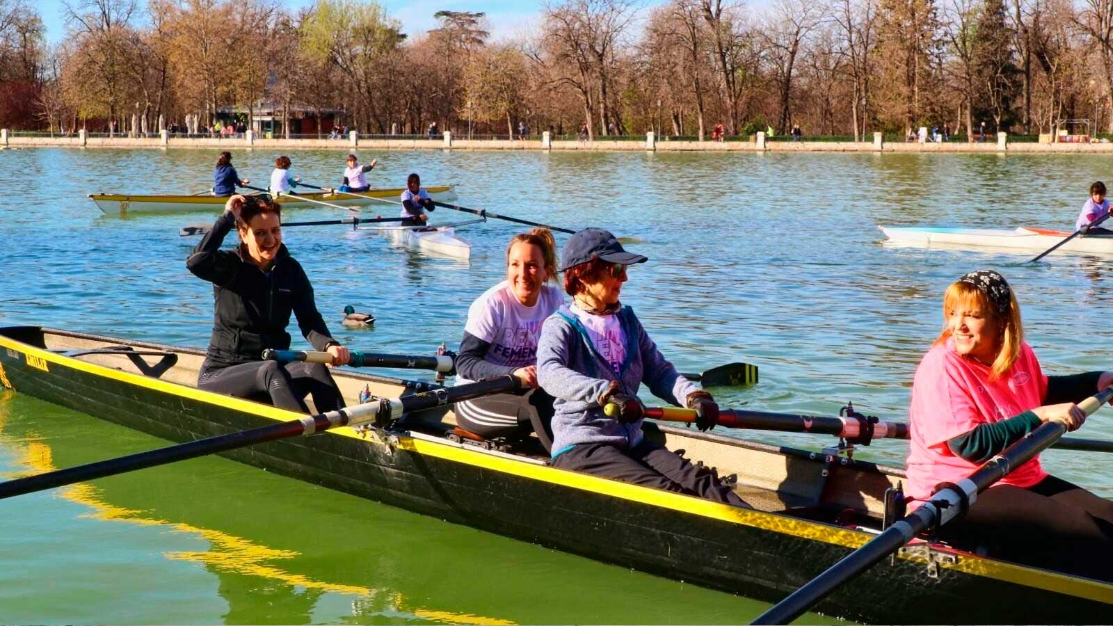 Varias mujeres practican remo en una embarcación colectiva en el estanque de El Retiro