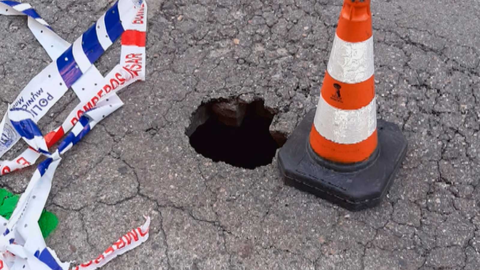 Socavón señalizado con un cono en una calzada de Madrid