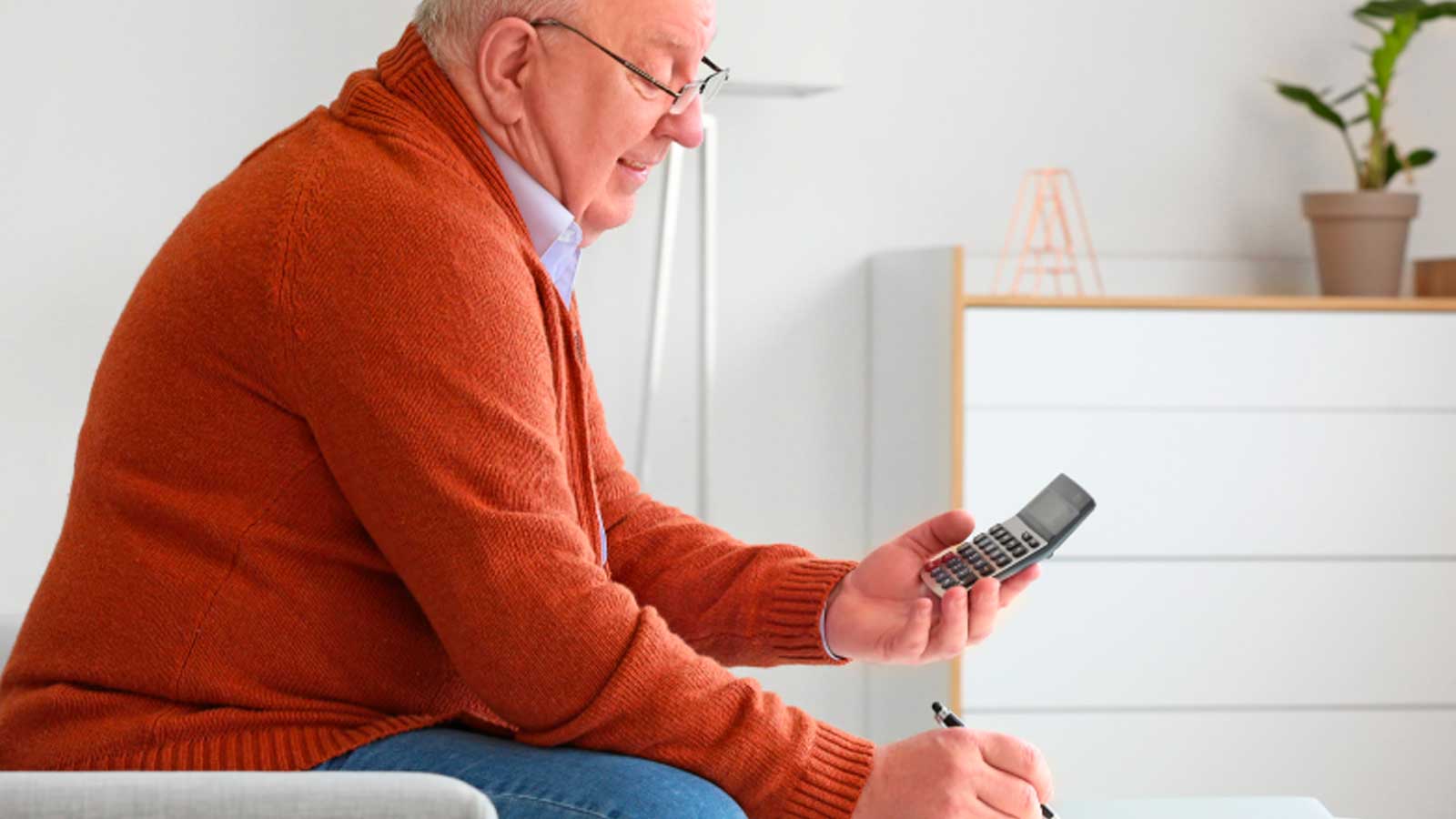 Jubilado con una calculadora haciendo cuentas sobre su pensión