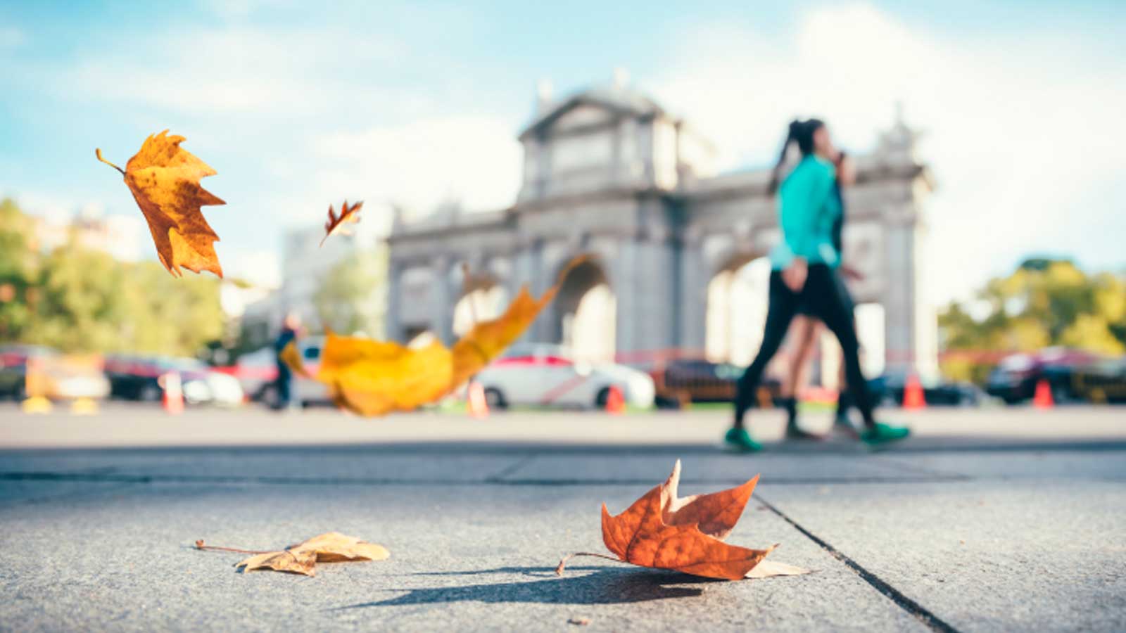 Hojas de otoño movidas por el viento junto a la Puerta de Alcalá de Madrid.