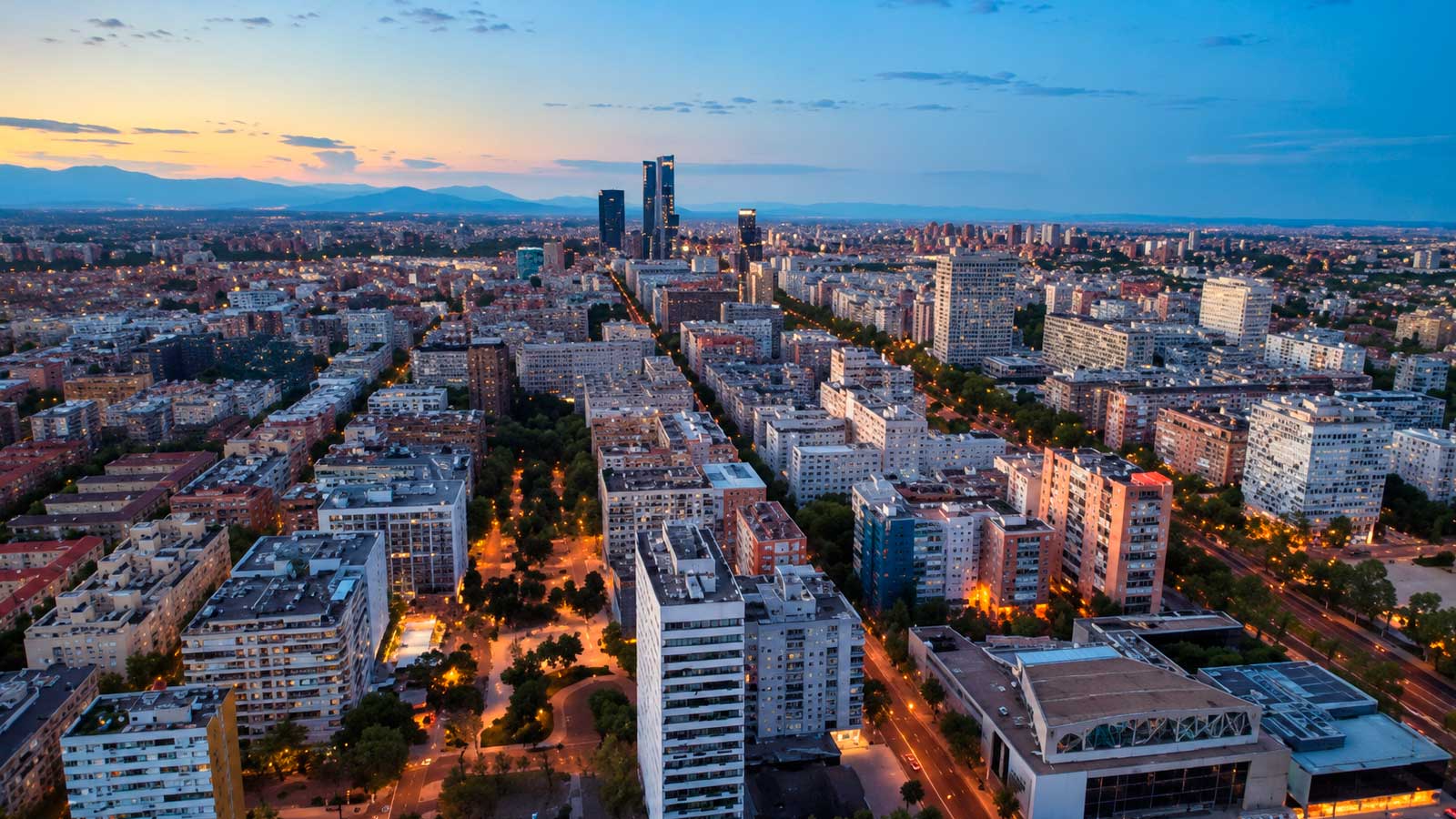 Vista panorámica de Madrid con las Cuatro Torres y el cielo despejado al atardecer.