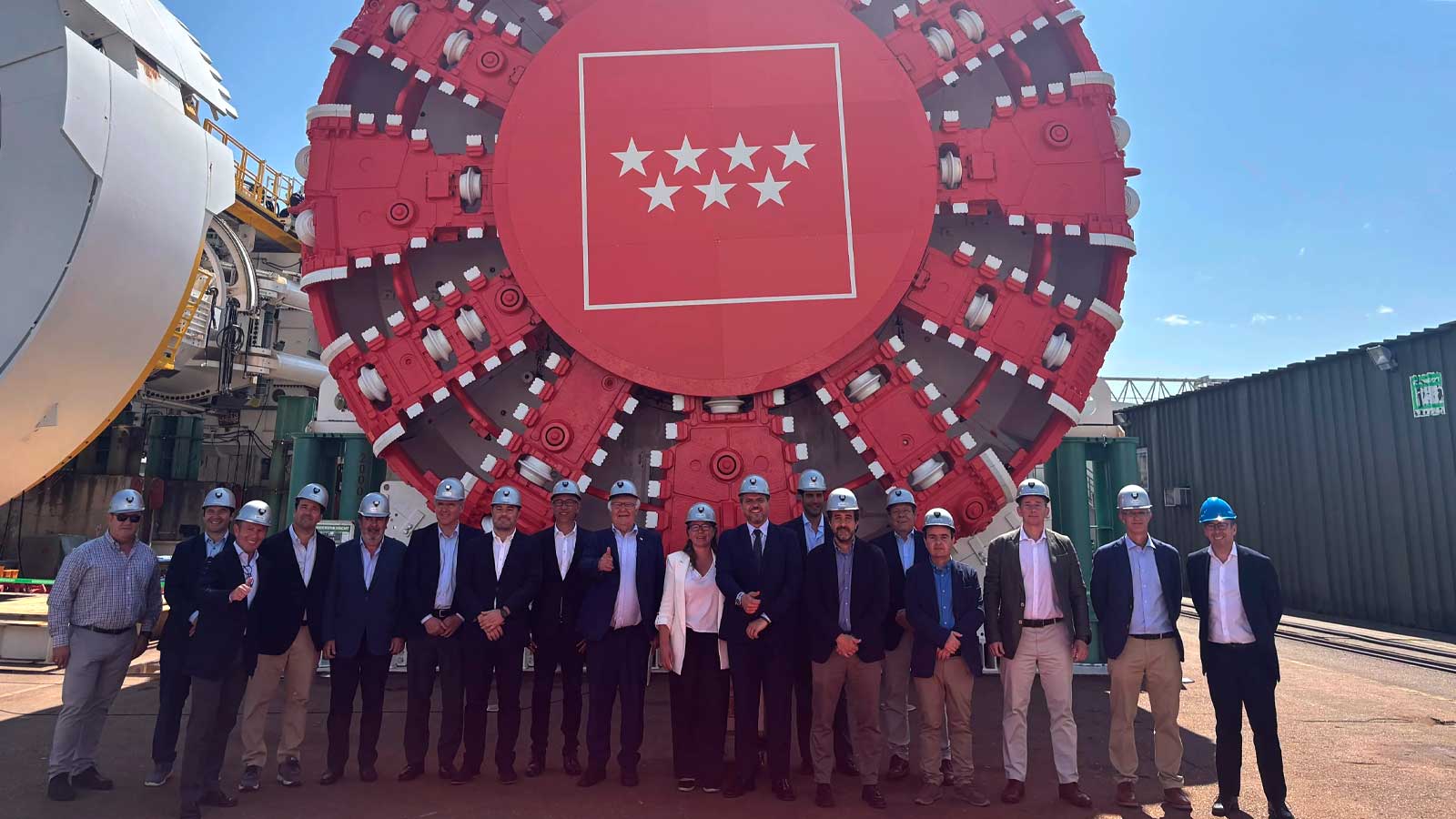 La tuneladora Mayrit de la línea 11 de Metro de Madrid junto a un grupo de personas con cascos de seguridad.